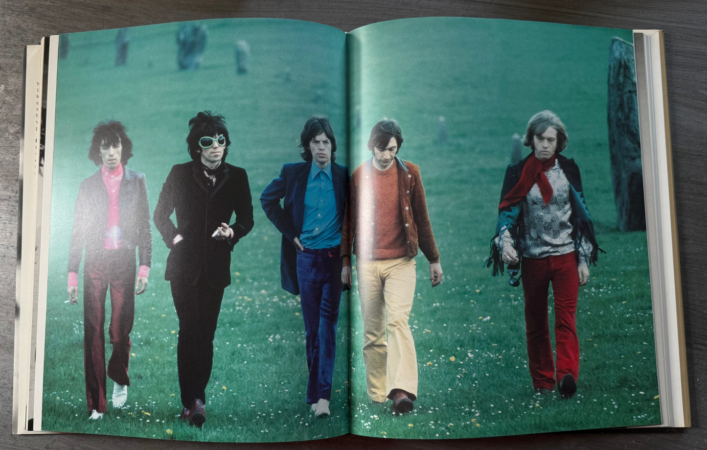 Double page spread of the Rolling Stones walking in a park.